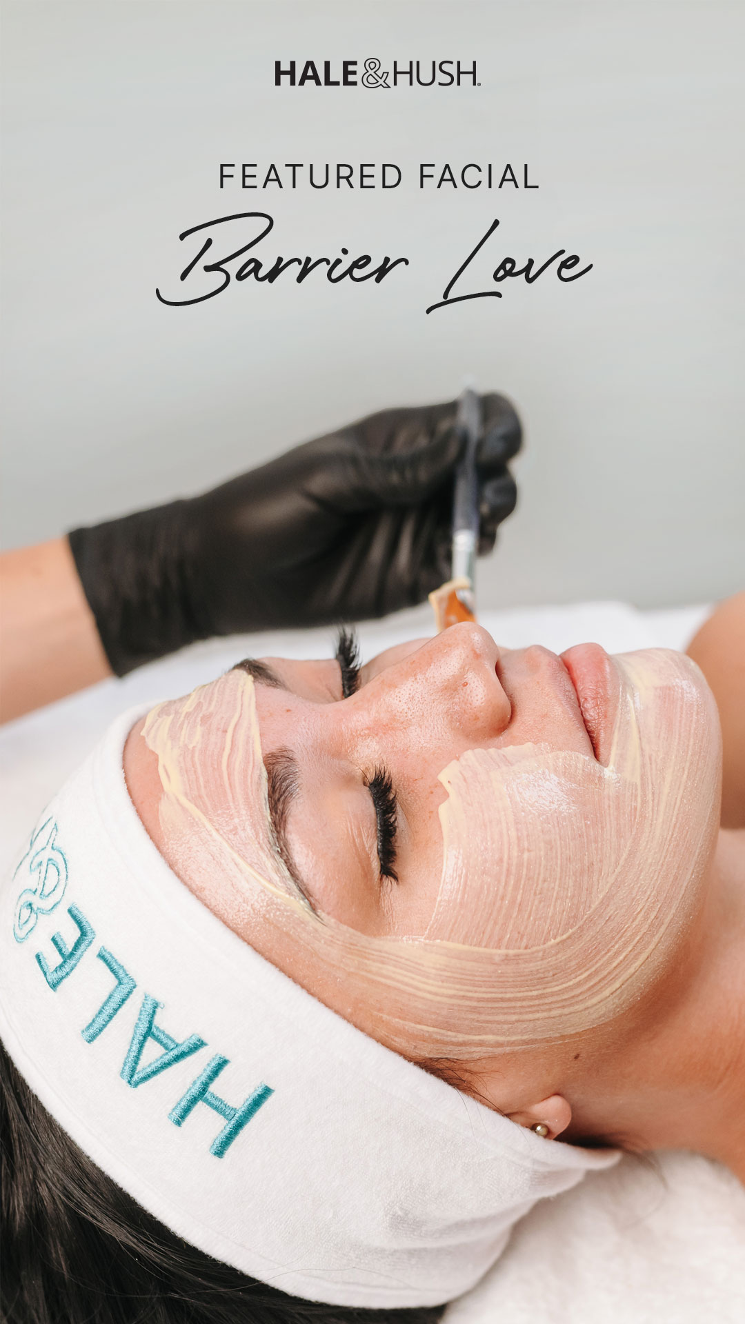 Woman in a headband laying on a table and a brush painting on a mask