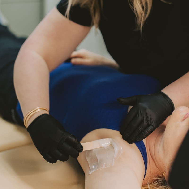 woman having her armpit waxed
